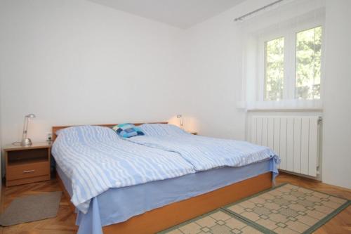 a white bedroom with a bed and a window at Holiday house with a parking space Veprinac, Opatija - 7699 in Veprinac