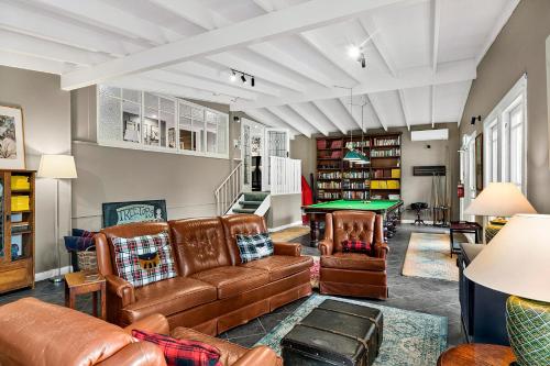 a living room with leather furniture and a pool table at The Bundanoon Guest House in Bundanoon