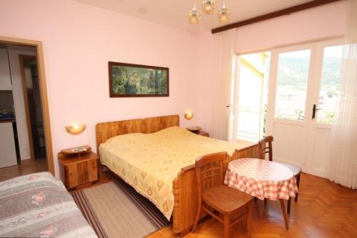 a bedroom with a bed and a table and chairs at Apartments with a parking space Cres - 7994 in Cres