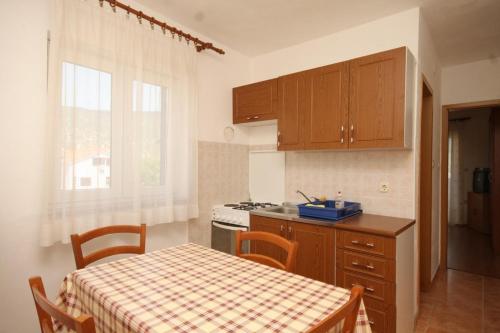 a kitchen with a table and a stove and a table and chairs at Apartments with a parking space Cres - 7994 in Cres
