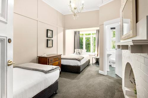 a bedroom with two beds and a fireplace at The Bundanoon Guest House in Bundanoon