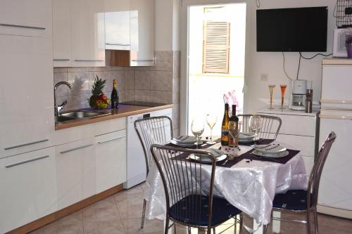 a kitchen with a table and chairs with wine bottles at Apartments with a parking space Ravni, Labin - 7674 in Ravni