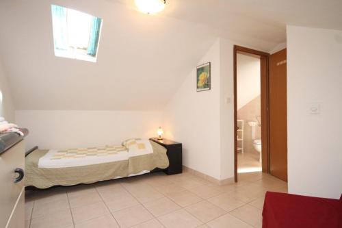 a small bedroom with a bed and a bathroom at Holiday apartments Osor, Losinj - 8004 in Nerezine