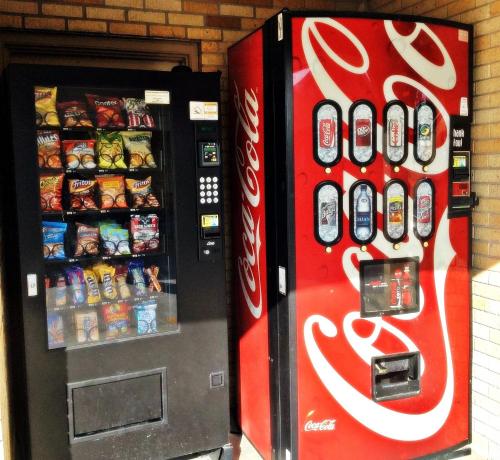 uma máquina de venda automática de coca cola ao lado de uma máquina de refrigerantes em Economy Inn em Thibodaux