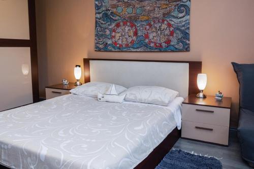 um quarto com uma grande cama branca com duas mesas de cabeceira em Apartments with WiFi Rijeka - 7825 em Rijeka