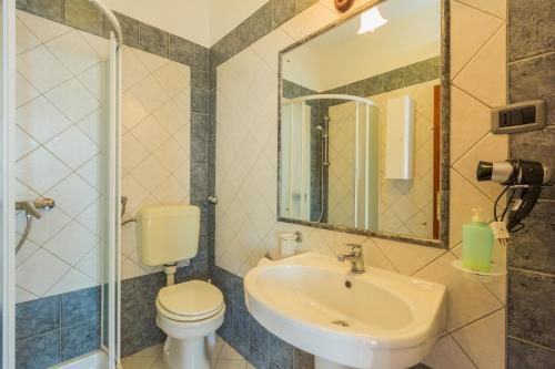 a bathroom with a sink and a toilet and a mirror at Apartments and rooms by the sea Moscenicka Draga, Opatija - 7767 in Mošćenička Draga