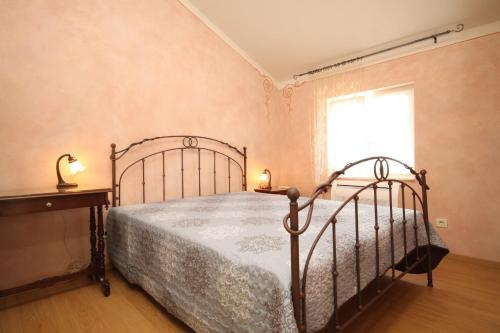 a bedroom with a metal bed and a window at Holiday house with a parking space Nerezine, Losinj - 8016 in Nerezine