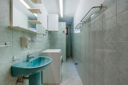 a bathroom with a blue sink and a toilet at Apartments and rooms with parking space Nerezine, Losinj - 8049 in Nerezine