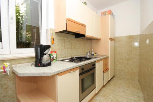 Una pequeña cocina con estufa y fregadero. en Apartments by the sea Moscenicka Draga, Opatija - 7833, en Mošćenička Draga