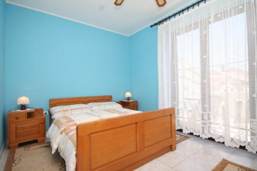 ein blaues Schlafzimmer mit einem Bett und einem Fenster in der Unterkunft Apartments with WiFi Susak, Losinj - 8047 in Susak