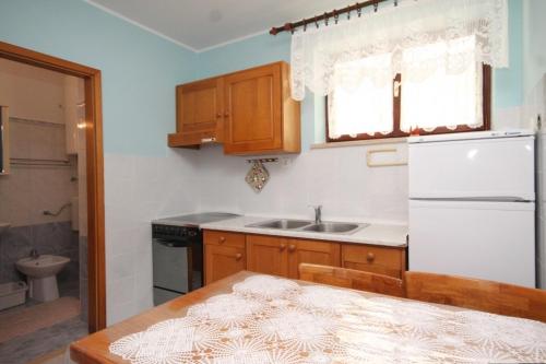 a kitchen with a white refrigerator and a sink at Apartments with WiFi Susak, Losinj - 8047 in Susak