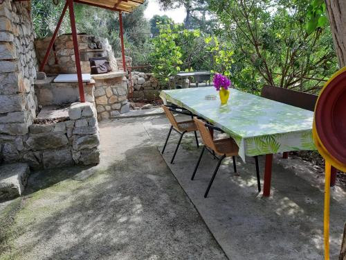 a table with chairs and a vase of flowers on it at Apartments by the sea Mali Losinj (Losinj) - 7996 in Mali Lošinj