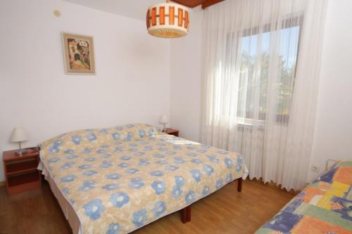 a bedroom with a bed and a window at Apartments with a parking space Mali Losinj (Losinj) - 7969 in Mali Lošinj