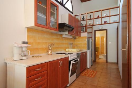 a kitchen with wooden cabinets and a stove top oven at Apartments with a parking space Mali Losinj (Losinj) - 7969 in Mali Lošinj