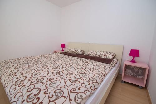 una camera con un grande letto con copriletto marrone e bianco di Apartments by the sea Veli Losinj, Losinj - 8031 a Veli Lošinj (Lussingrande)