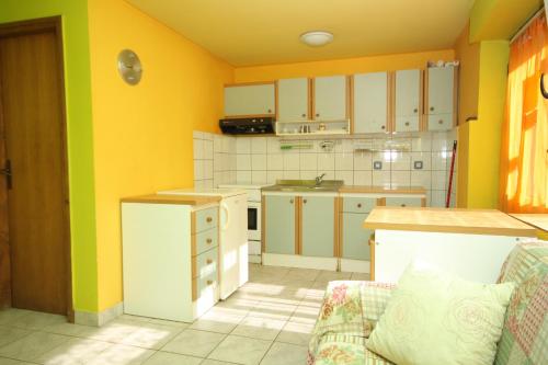 una cucina con pareti gialle ed elettrodomestici bianchi di Apartments by the sea Veli Losinj, Losinj - 8031 a Veli Lošinj (Lussingrande)