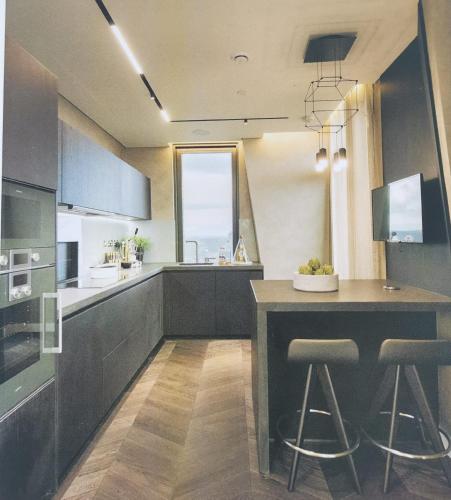 a kitchen with a island with two bar stools at Parliament House - Luxury Penthouse in London