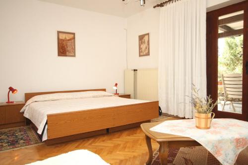 a bedroom with a large bed and a table at Apartments with WiFi Mali Losinj (Losinj) - 7992 in Mali Lošinj