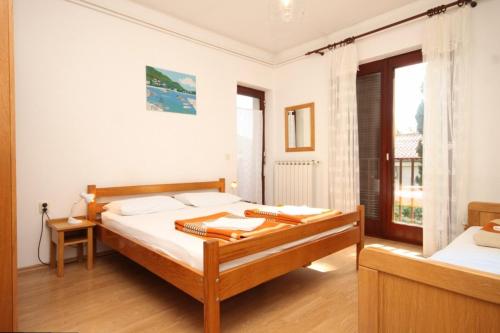 a white bedroom with a bed and a window at Apartments by the sea Icici, Opatija - 7745 in Ičići