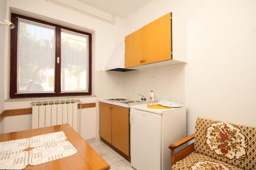 a small kitchen with a table and a sink at Apartments by the sea Icici, Opatija - 7745 in Ičići