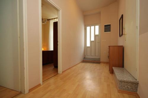 Apartments by the sea Opatija - 7830 في أوباتيا: غرفة فارغة مع أرضيات خشبية وجدران بيضاء