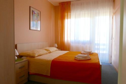 - une chambre avec un lit et des serviettes dans l'établissement Apartments with a parking space Opatija - 7831, à Opatija