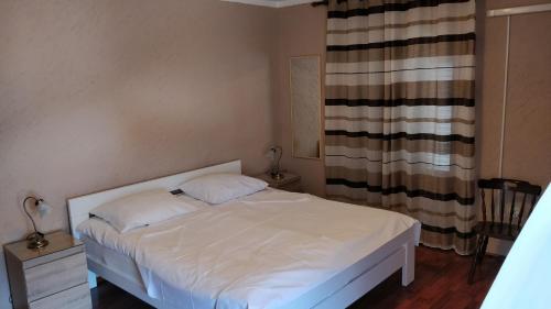 a small bedroom with a white bed and a window at Apartments by the sea Mali Losinj (Losinj) - 8001 in Mali Lošinj