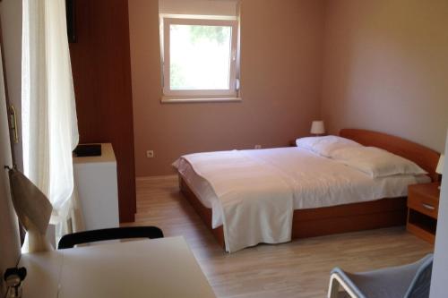 a bedroom with a bed and a window at Apartments with a parking space Opatija - 7919 in Opatija