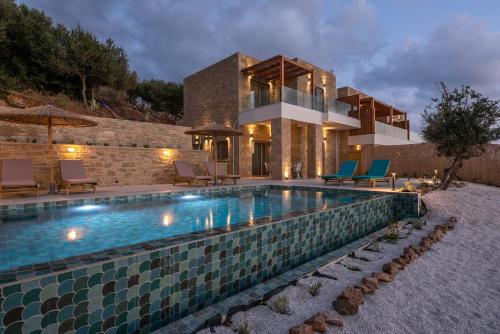 a swimming pool in front of a house at Alma Natura Villas Falasarna- Avgerinos Villa in Falasarna