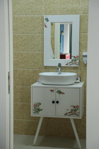 y baño con lavabo y espejo. en NovART SeaVilla&Gallery Hotel, en Sumqayit