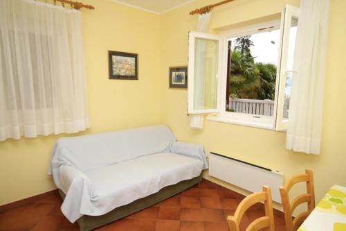 a white bed in a room with a window at Apartments with a parking space Icici, Opatija - 7988 in Ičići