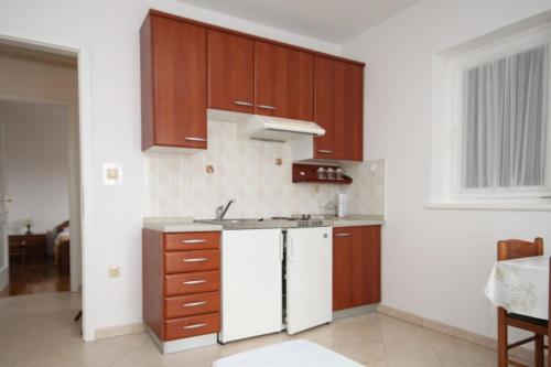 a kitchen with brown cabinets and a white refrigerator at Apartments with a parking space Icici, Opatija - 7988 in Ičići