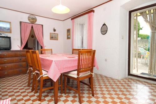 ein Esszimmer mit einem Tisch und Stühlen sowie einem TV in der Unterkunft Holiday house with a parking space Sveti Jakov, Losinj - 7950 in Nerezine