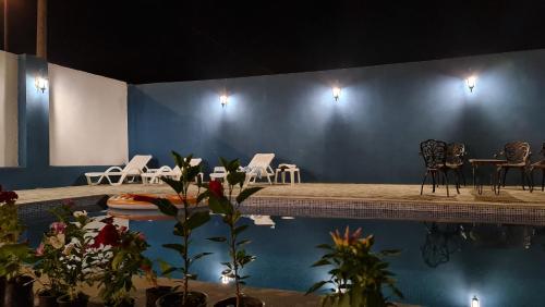 Habitación con piscina con sillas y mesas. en NovART SeaVilla&Gallery Hotel, en Sumqayit