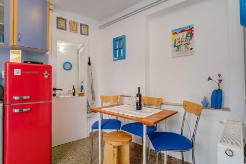 a kitchen with a red refrigerator and a table and chairs at Apartments by the sea Veli Losinj, Losinj - 7959 in Veli Lošinj