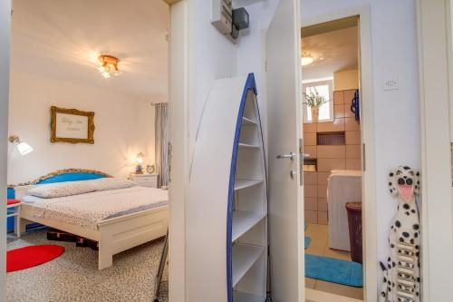a bedroom with a bed and a surfboard in a room at Apartments by the sea Veli Losinj, Losinj - 7959 in Veli Lošinj