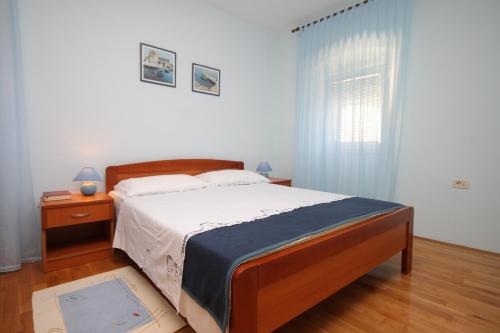 a bedroom with a large bed and a window at Apartment Mali Losinj 7979a in Mali Lošinj