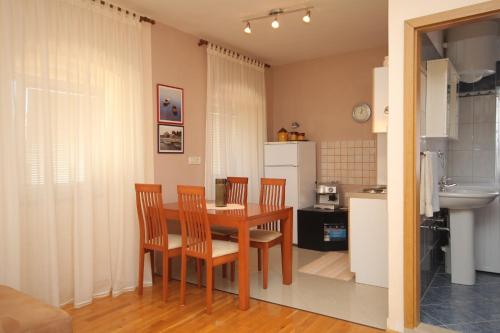 a kitchen and dining room with a table and chairs at Apartment Mali Losinj 7979a in Mali Lošinj