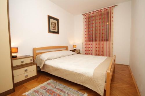 a bedroom with a bed and a dresser and a window at Apartments with a parking space Mali Losinj (Losinj) - 7998 in Mali Lošinj