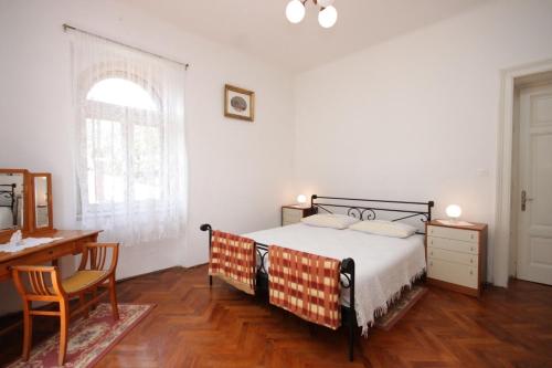 a bedroom with a bed and a desk and a window at Apartments with a parking space Lovran, Opatija - 7693 in Lovran