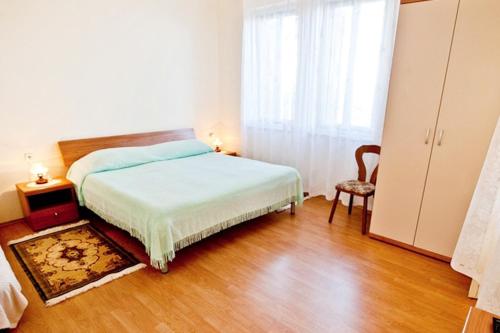 1 dormitorio con 1 cama, 1 silla y 1 ventana en Apartments by the sea Lovran, Opatija - 7708 en Lovran