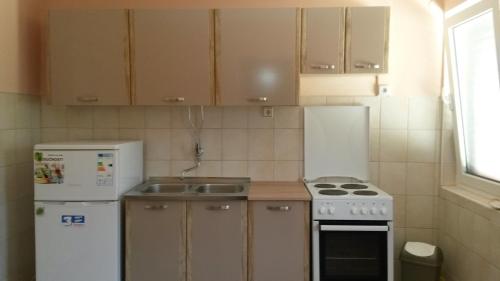a small kitchen with a stove and a refrigerator at Apartments with a parking space Opric, Opatija - 7716 in Lovran