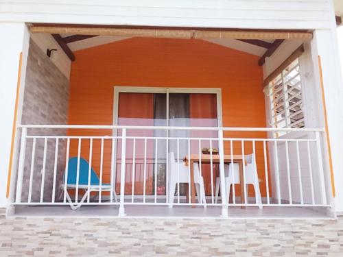 a balcony of a house with a table and chairs at Nouveau logement T2 avec vue sur mer et montagne in Sainte-Rose