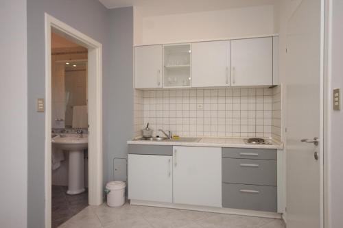 a kitchen with white cabinets and a sink at Apartments with a parking space Icici, Opatija - 7761 in Ičići
