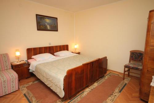 a bedroom with a bed with two lamps and a chair at Apartments with a parking space Icici, Opatija - 7788 in Ičići