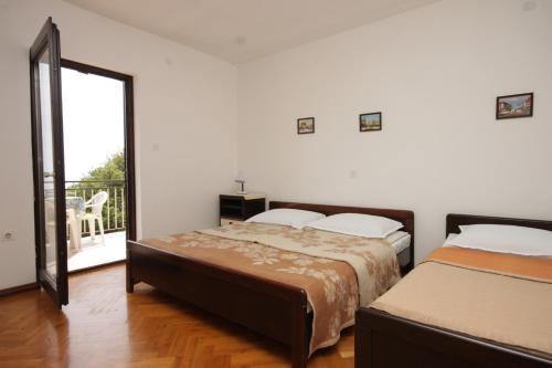 a bedroom with two beds and a balcony at Apartments with a parking space Icici, Opatija - 7763 in Ičići