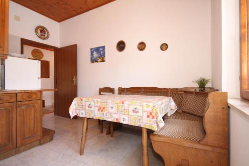 a kitchen with a table with a table cloth on it at Apartments by the sea Mali Losinj (Losinj) - 8006 in Mali Lošinj