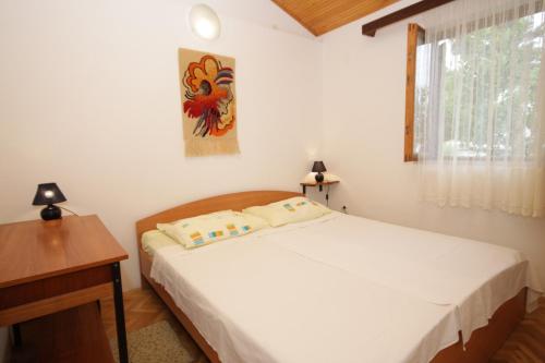 Schlafzimmer mit einem Bett, einem Schreibtisch und einem Fenster in der Unterkunft Apartments by the sea Mali Losinj (Losinj) - 8006 in Mali Lošinj