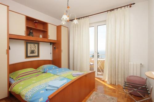 a bedroom with a bed and a large window at Apartments with a parking space Icici, Opatija - 7793 in Ičići