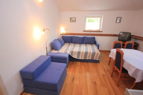 a bedroom with a bed and a blue couch at Family friendly seaside apartments Moscenicka Draga, Opatija - 7798 in Mošćenička Draga